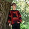 A man wearing a Sunset Orange Baja Hoodies against a gnarly tree.