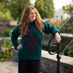 Woman wearing a green sweater with a red pattern, standing outdoors.