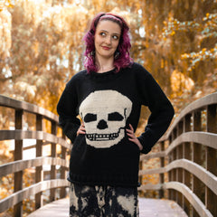 Woman wearing a black sweater with a skull design in an autumn setting