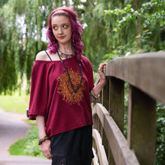 Woman with pink hair standing on a wooden bridge in a park