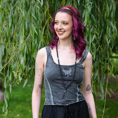 Woman with purple hair standing in front of a willow tree