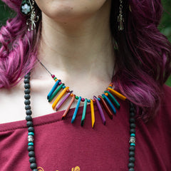 Person wearing a colorful beaded necklace with a maroon top.