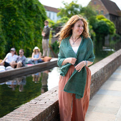 Woman standing by a canal with people in the background